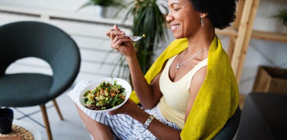 Woman eating a salad to promote healthy gut health