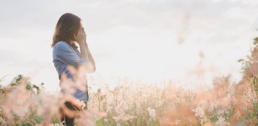 Girl standing in field feeling depressed and anxious from lyme disease's effect on her mental health