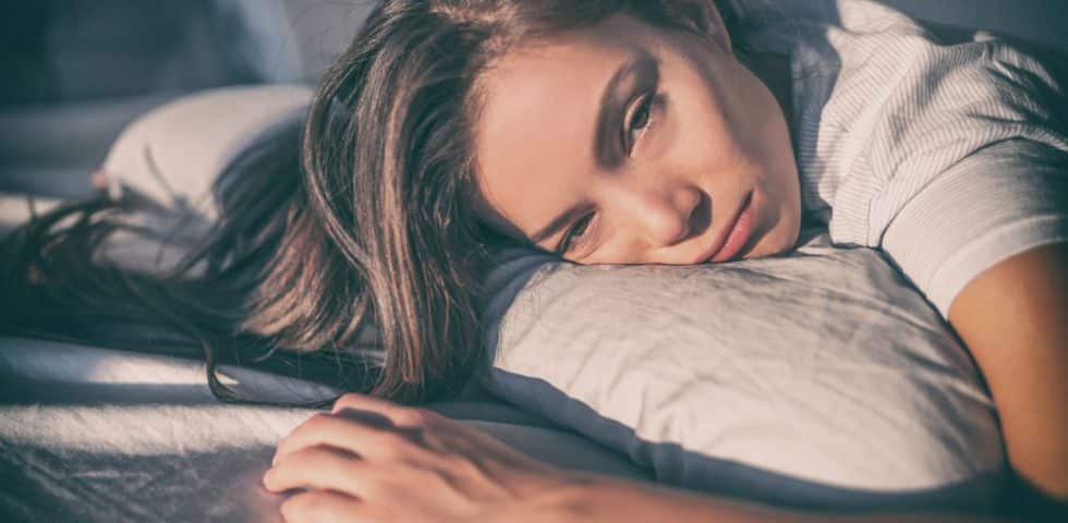 Woman laying in bed with chronic fatigue from Lyme Disease